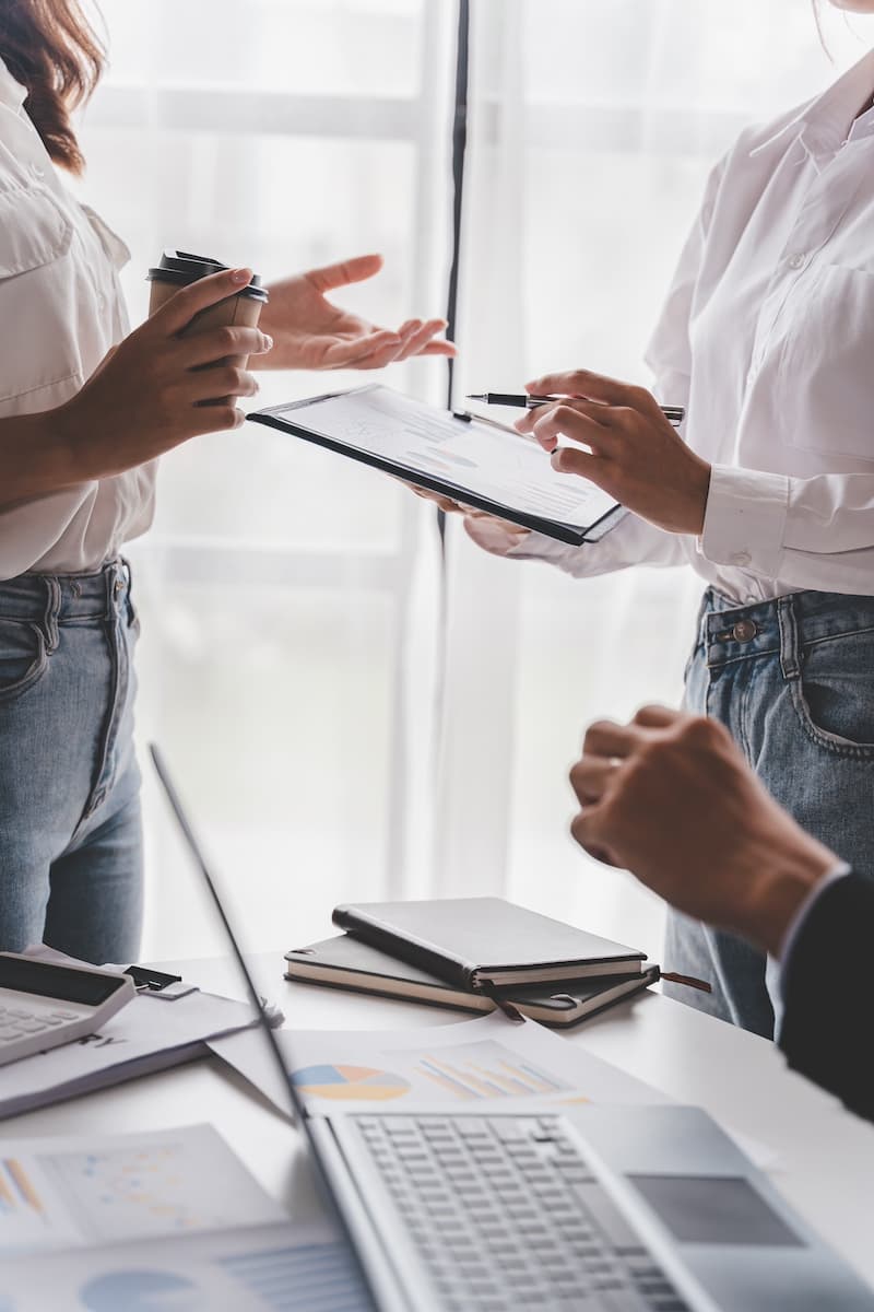 Three people exchanging documents